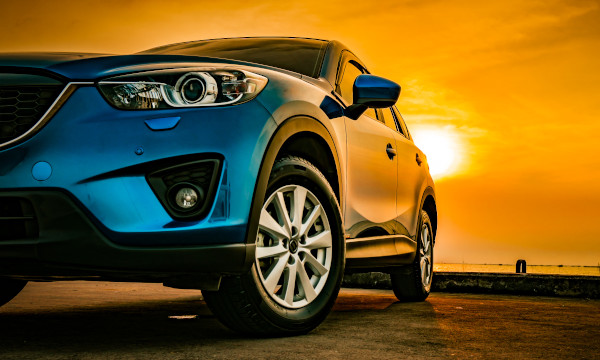 Photo of a car in front of a sunset