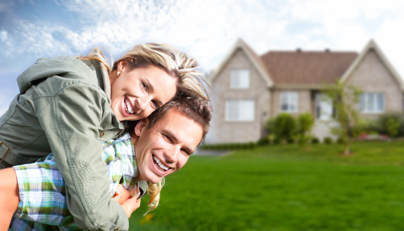 young couple in front of their new house.
